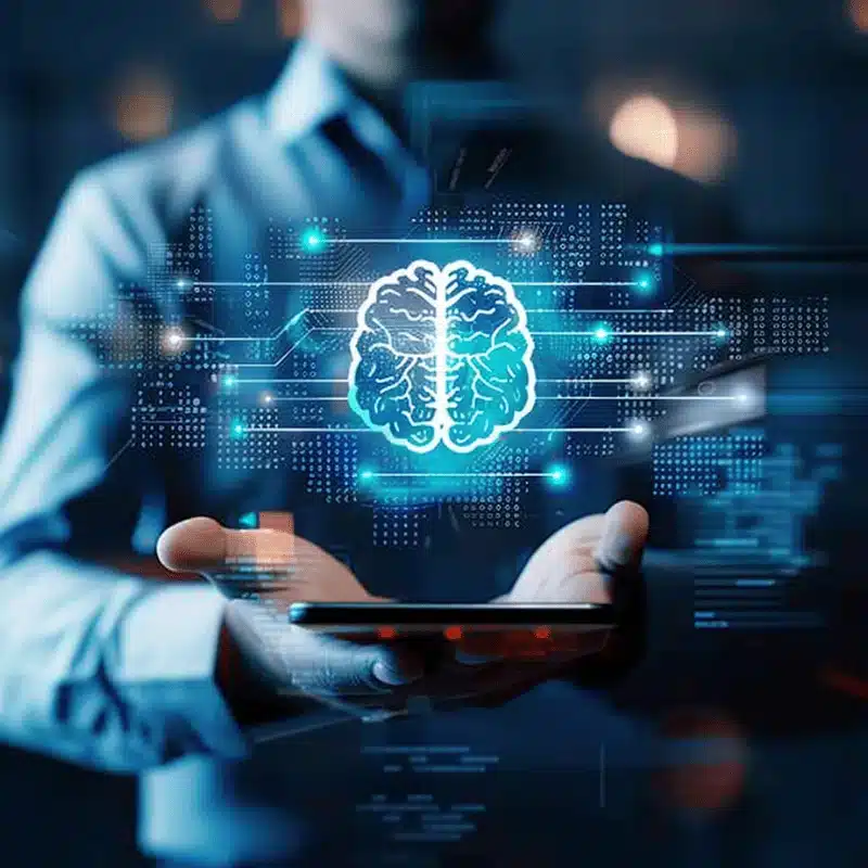 Formations IA – Prêts à intégrer l’intelligence artificielle avec Digitalchimist Illustration d'un cerveau digital flottant au-dessus d'un smartphone, symbolisant l'intégration de l'IA avec Digitalchimist